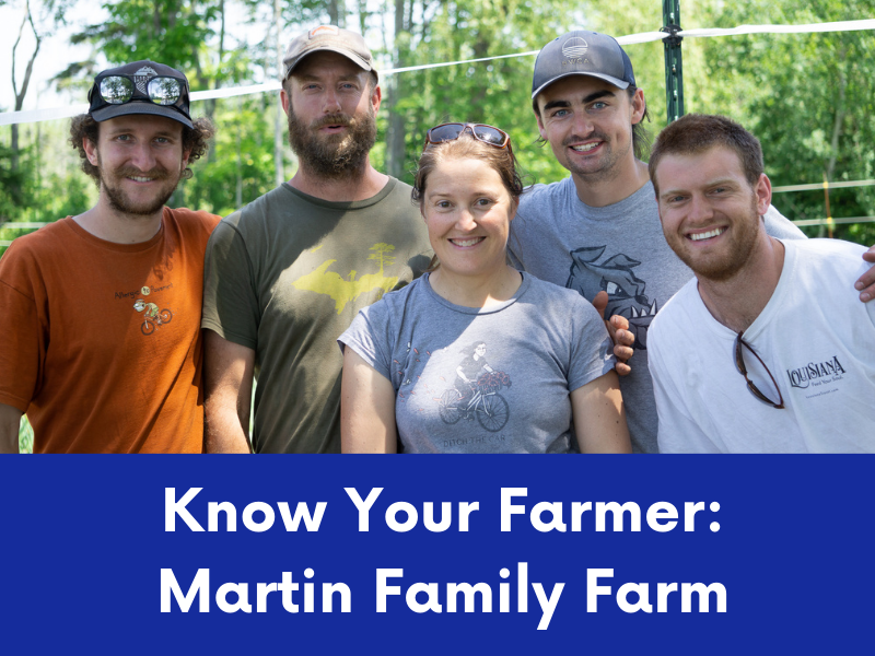 Five smiling individuals, appearing to be young adult farmers, stand together outdoors, possibly on their farm.