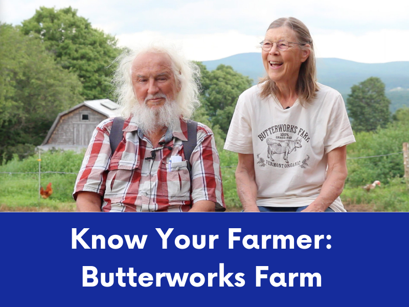 An elderly man with a long white beard and a smiling older woman wearing a "Butterworks Farm" t-shirt sit outdoors in a rural setting.