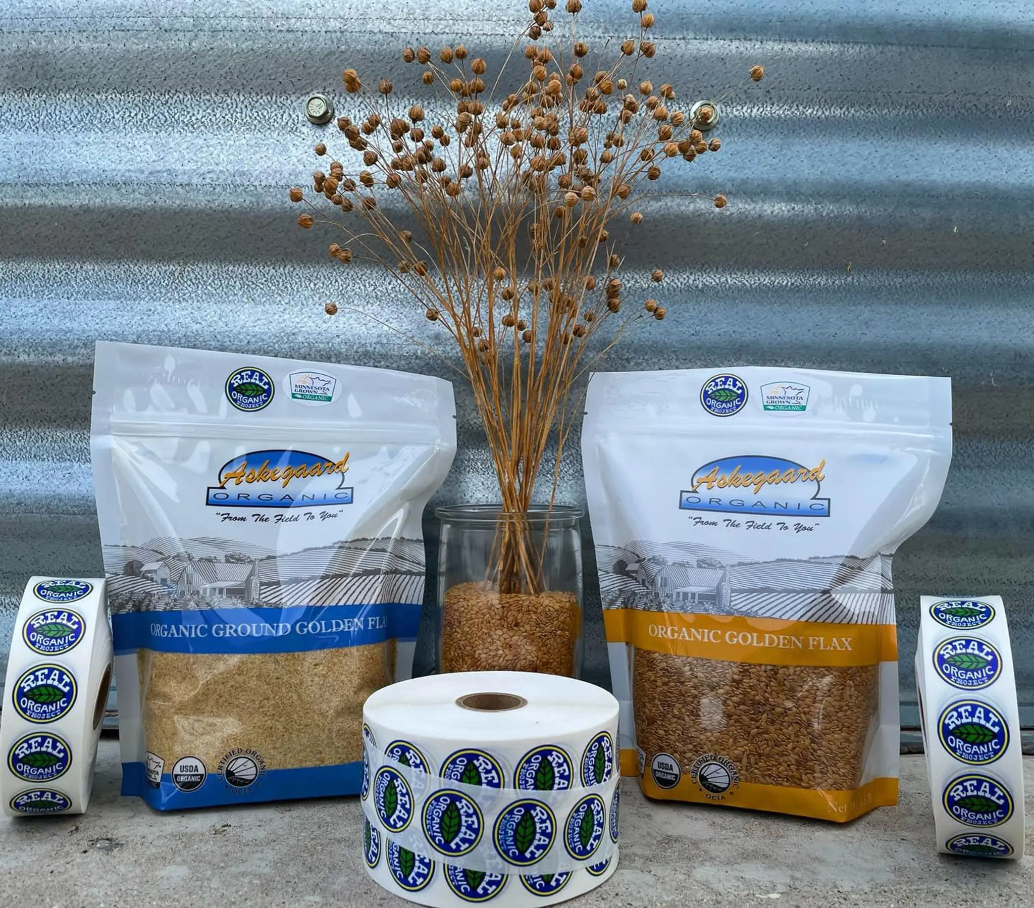 "Askegaard Organic" flax products with "REAL ORGANIC" stickers and dried flax.