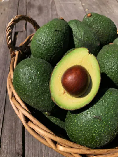 Basket of fresh organic avocados, showcasing nutrient-dense food grown sustainably.