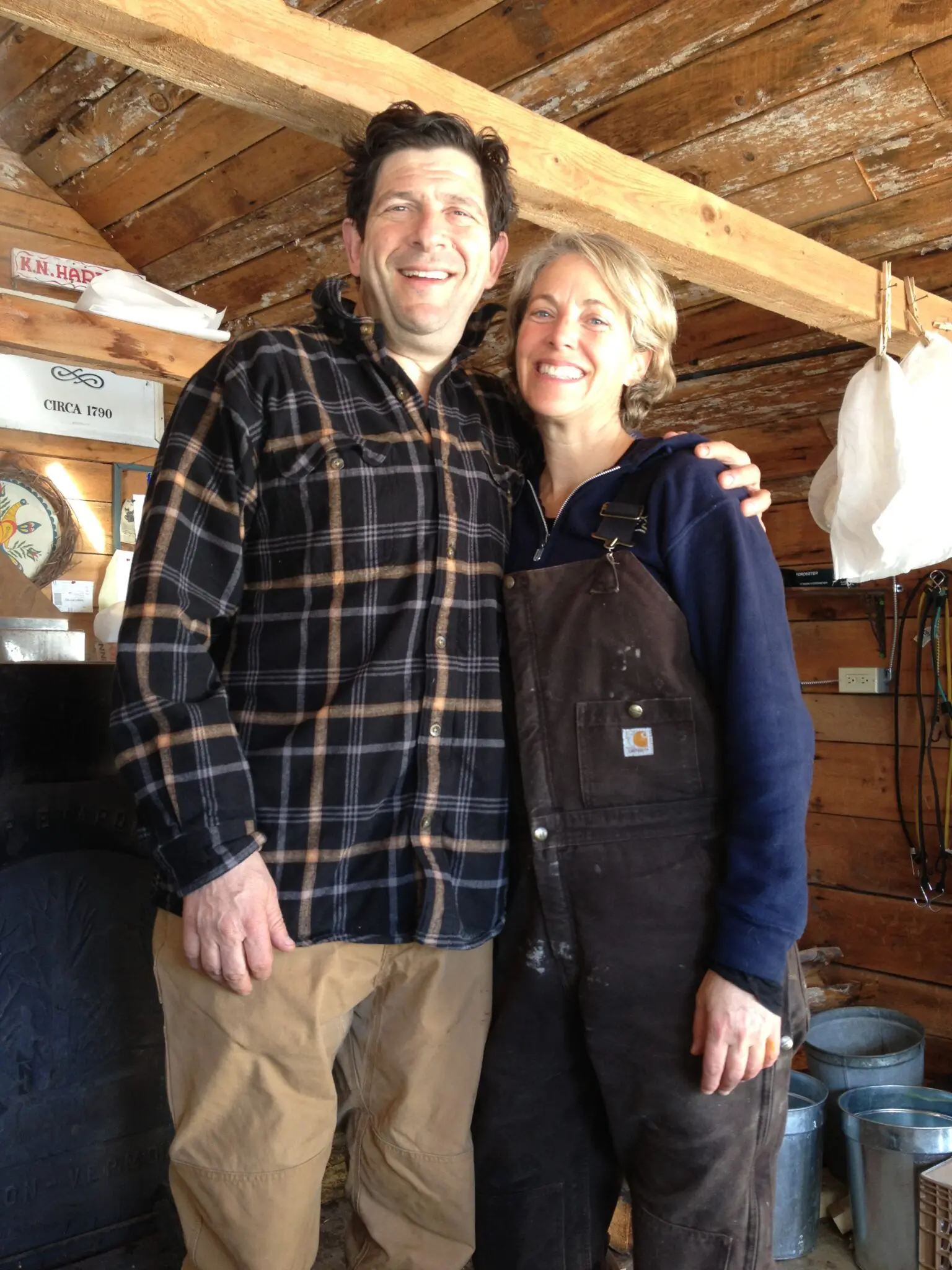 Charlie and Leigh Merinoff, a smiling man and woman, are standing together for an unknown podcast.