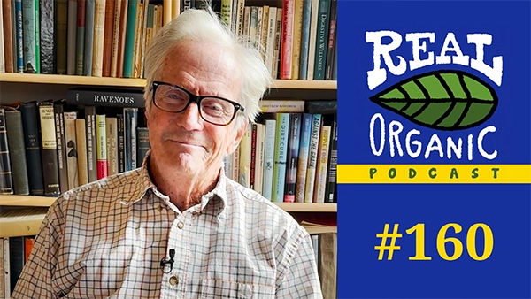 Eliot Coleman in his library in the fall 2023, in a checkered shirt and reading glasses, being interviewed for the Real Organic Podcast.