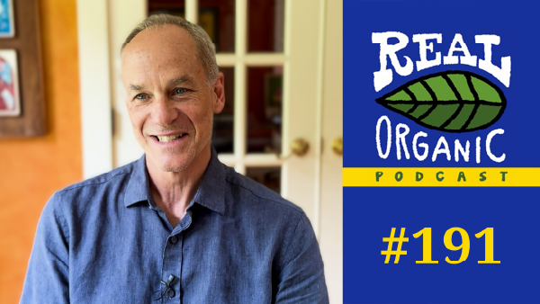 Marcelo Gleiser sits in Dave Chapman's living room wearing a blue shirt.