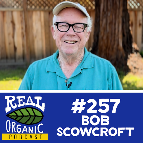 Bob Scowcroft smiles in a turquoise shirt in his backyard