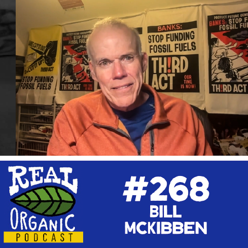 Bill McKibben smiles from his desk in front of Third Act posters