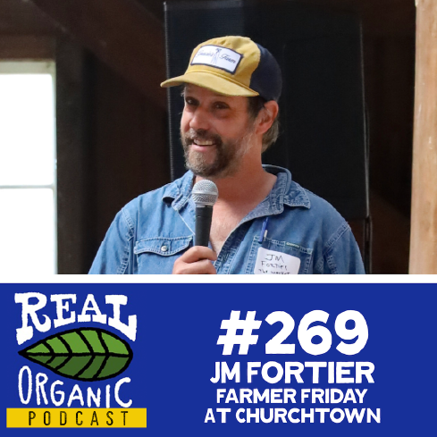 JM Fortier in a denim shirt holding a microphone at Churchtown Dairy